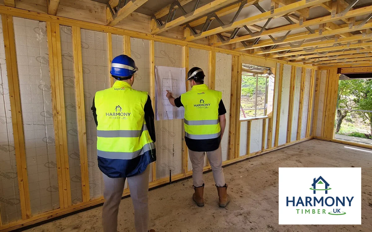 Two men on building site looking at blueprints