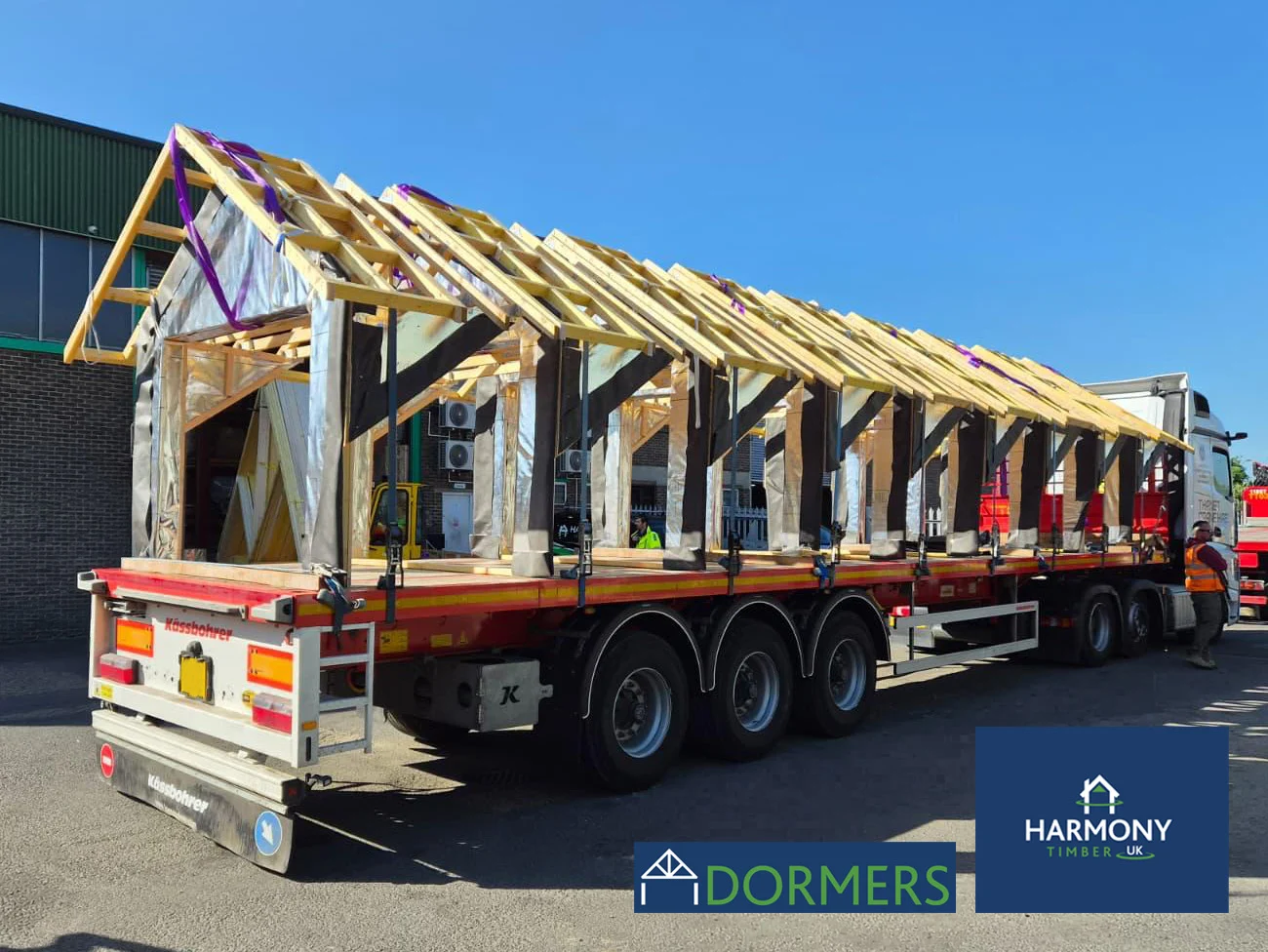 Dormers loaded and secured to a flat bed lorry ready for delivery on a bright day