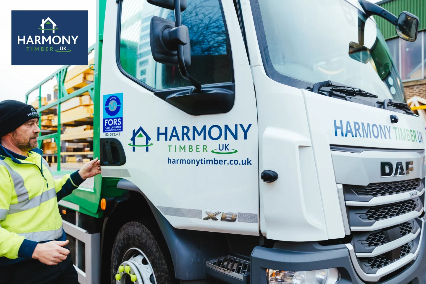 Close up of white Harmony branded lorry with a man in a high vis jacket opening the door