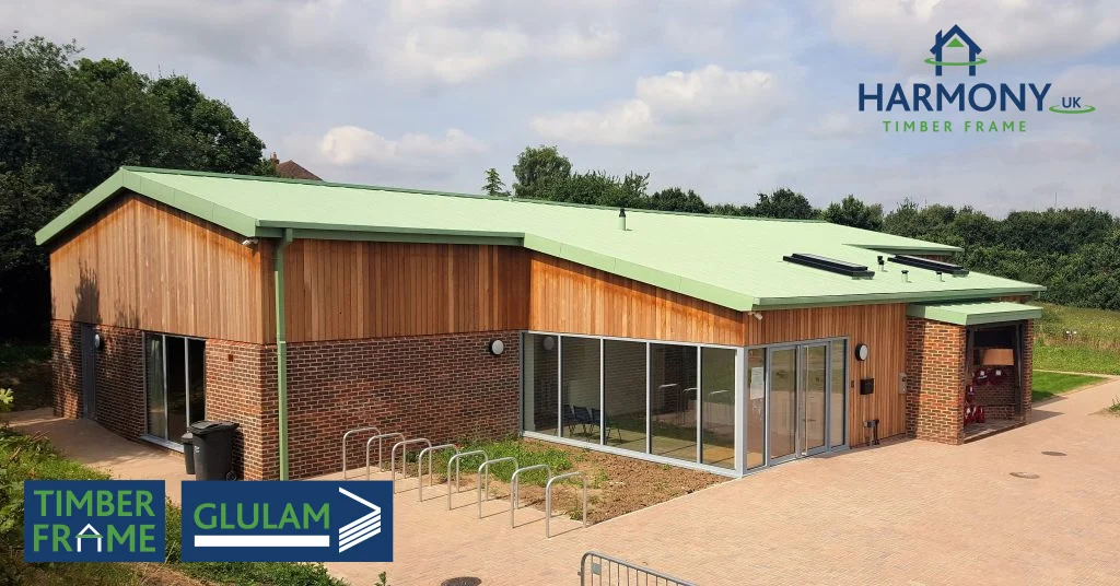 Large timber building with green roof surrounded by trees